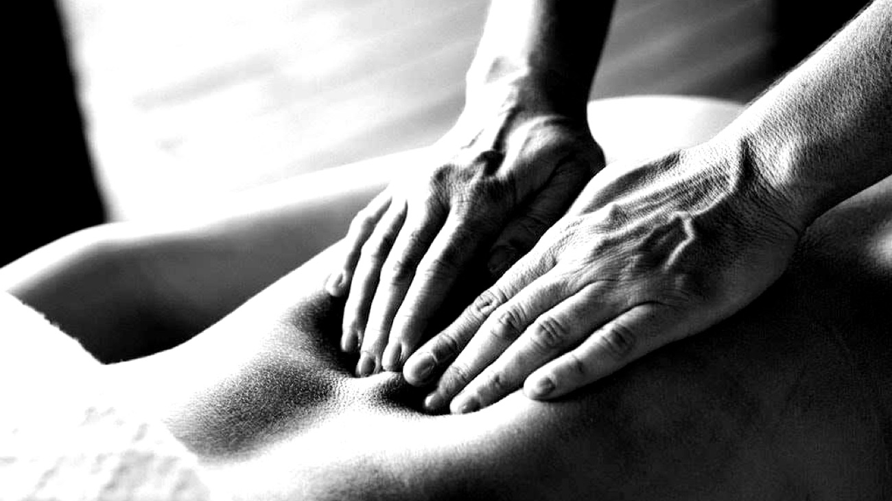 Close-up of a deep tissue back massage in black and white