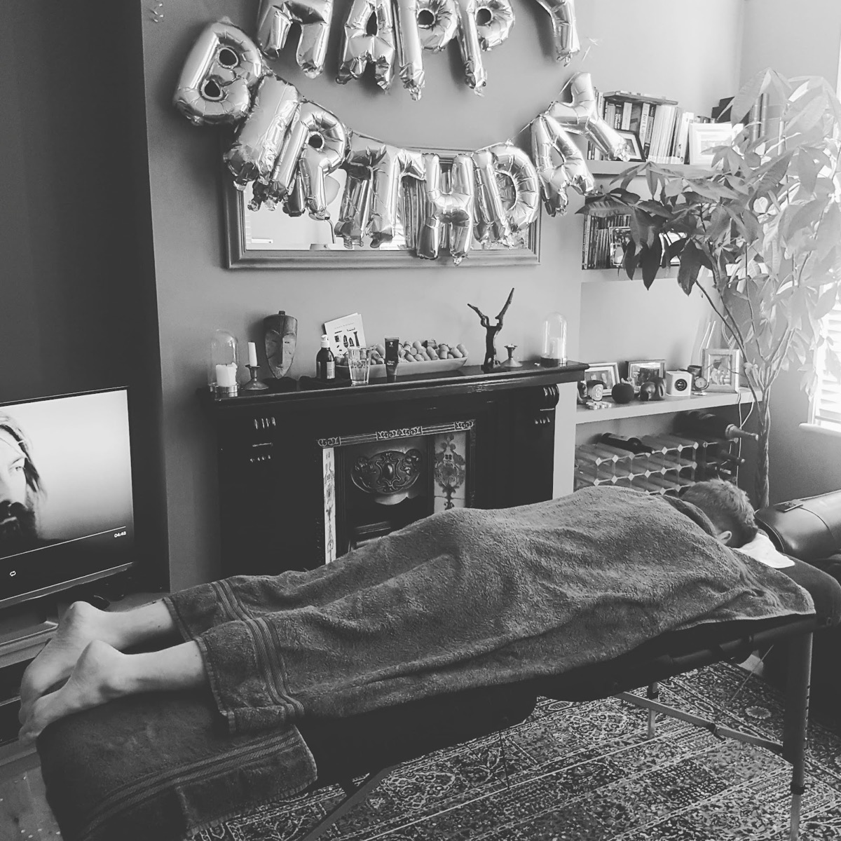 A home-visit massage session in black and white